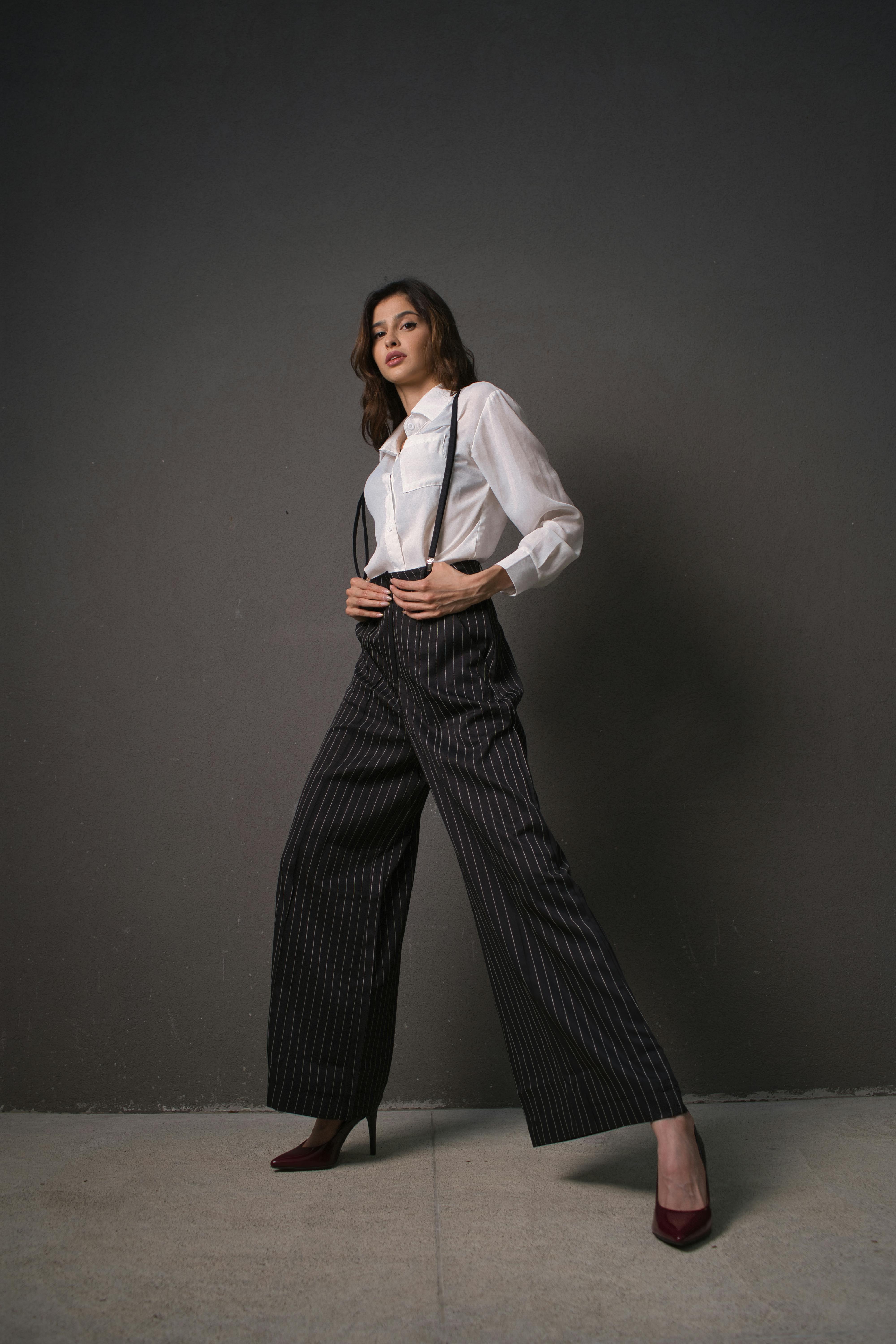 a woman in a white shirt and black pinstripe pants