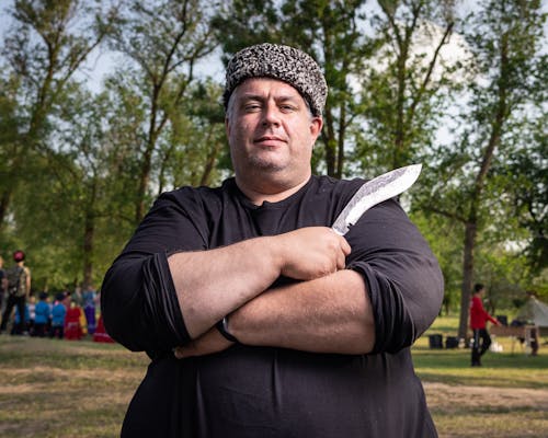 A Man Standing Outside and Holding a Sharp Knife 