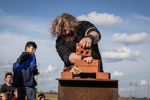 Man Crashing Brick by his Hand