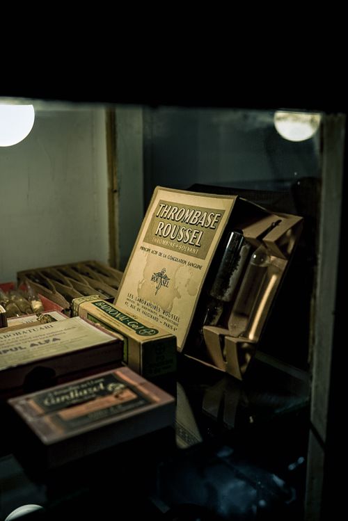 Free A dimly lit vintage cigar display featuring old cigar boxes inside a glass cabinet. Stock Photo