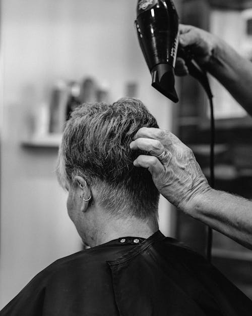 View of a Hairdresser Drying the Hair of a Client 