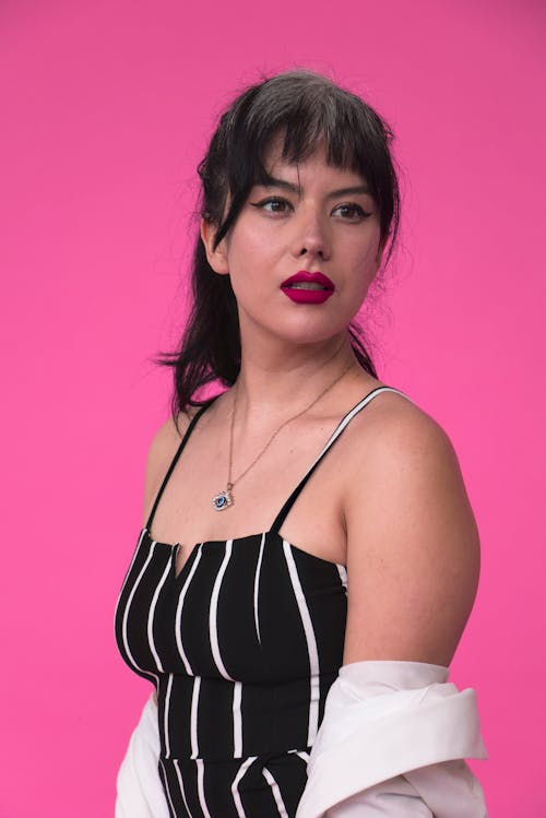 Young Woman in Black Top Against Pink Background