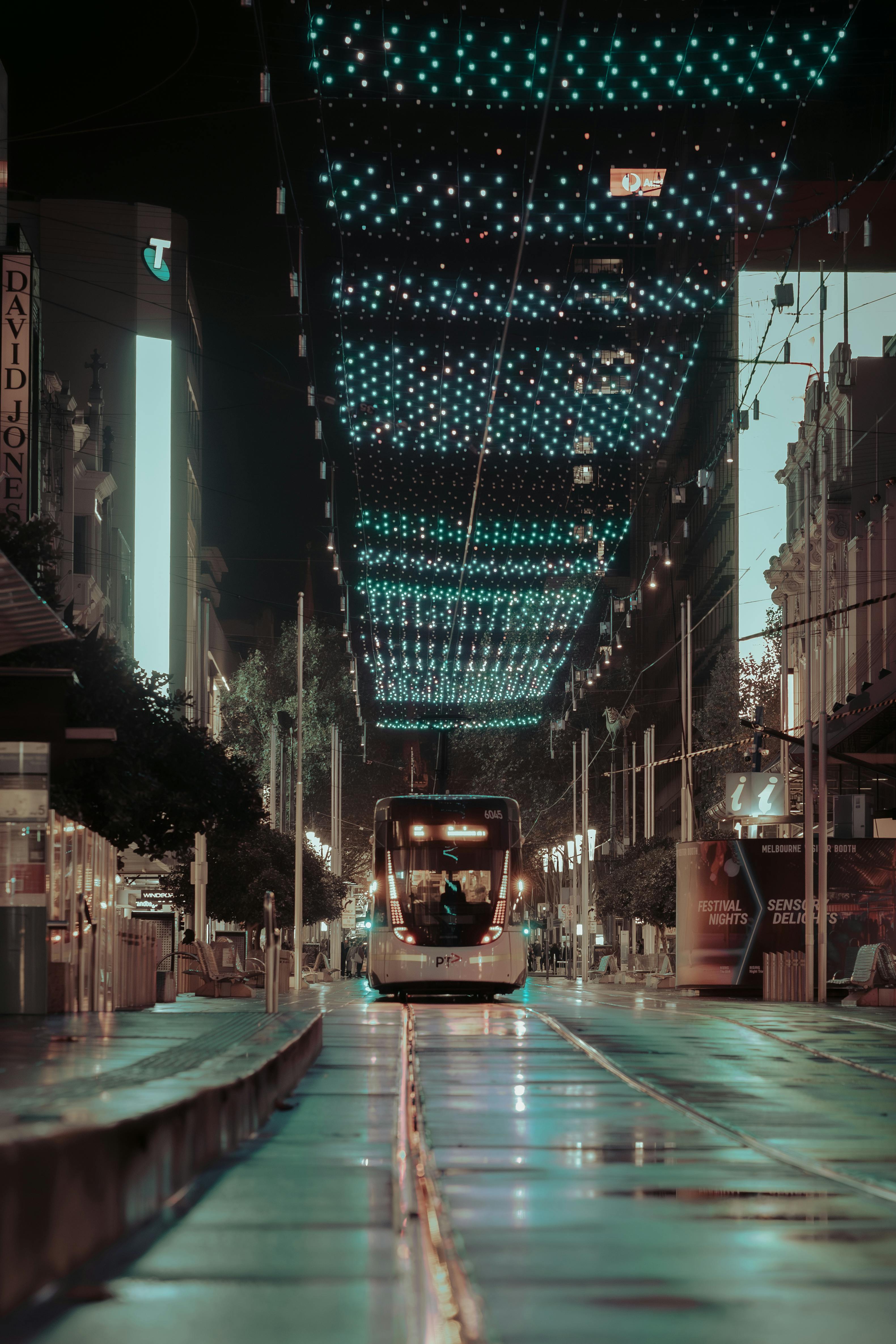 Free A mesmerizing night scene of a tram under illuminated lights on a Melbourne street. Stock Photo