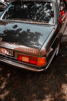 A classic BMW 735i car parked outdoors in Türkiye, showcasing retro charm under sunlight and shadows.