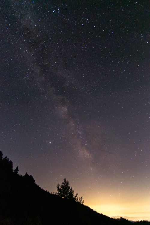 Free Spectacular view of the Milky Way galaxy over a silhouetted landscape at night. Stock Photo