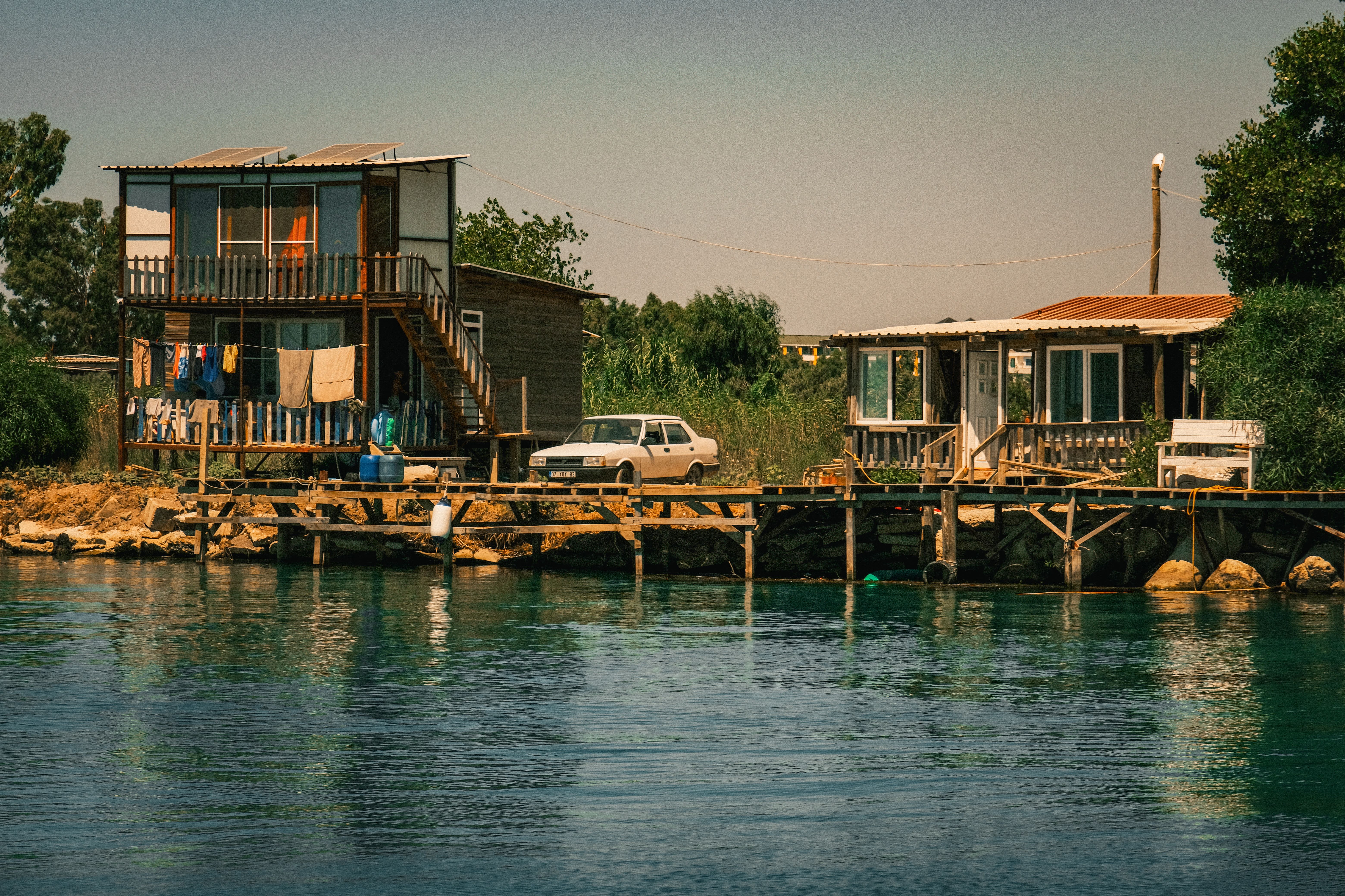 Charming riverside bungalows with a car and pier in sunny Antalya, Turkey.