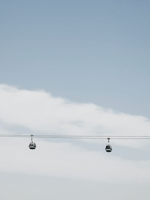 Free Cable cars suspended against a clear blue sky in Porto, Portugal, offering a breathtaking aerial view. Stock Photo