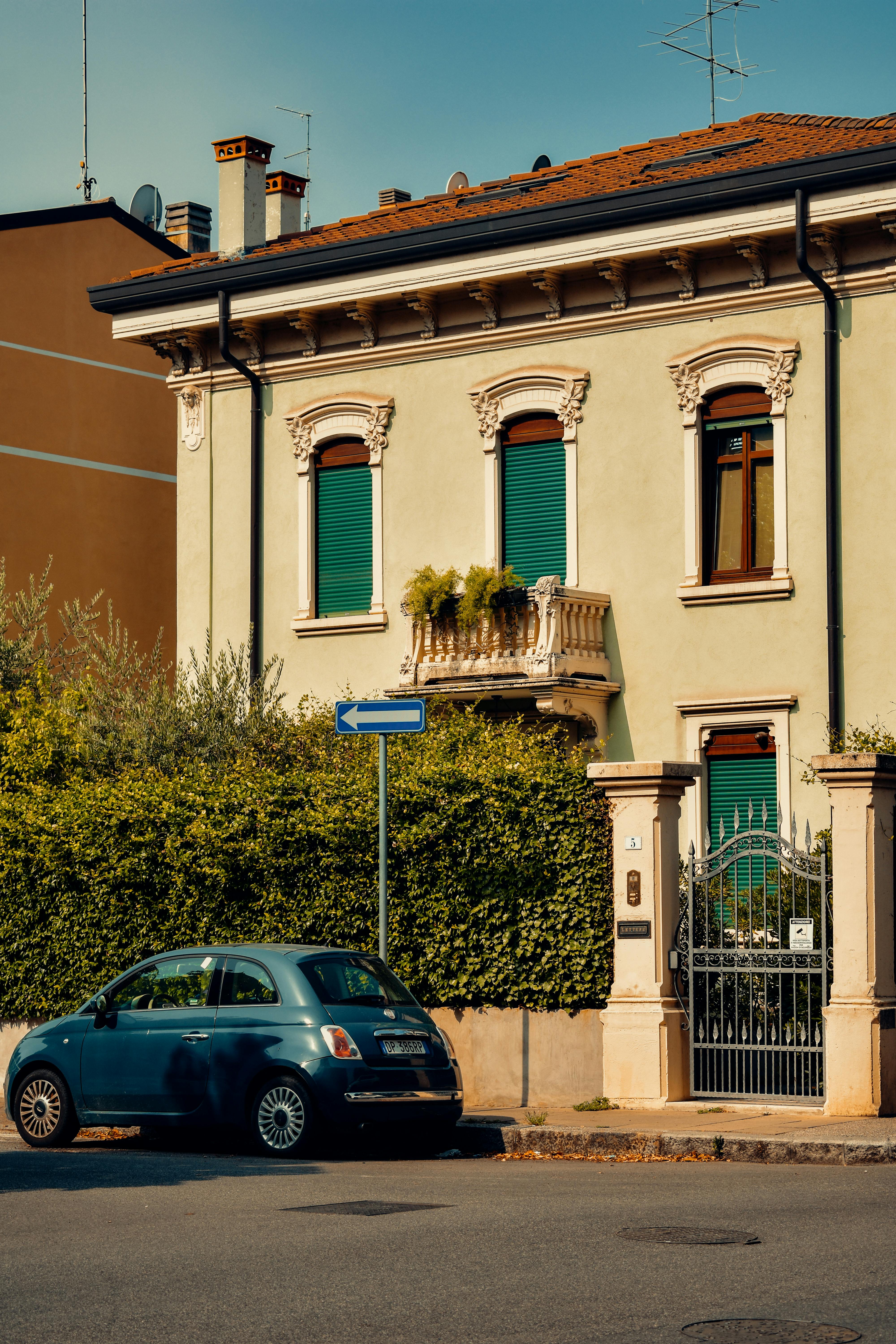 A serene street scene in Verona, Italy, featuring a vintage building and parked car under bright daylight.