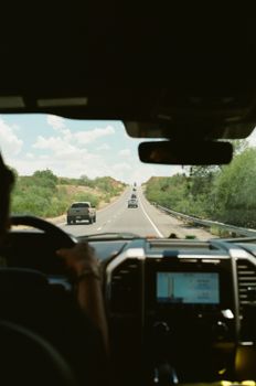 View from inside a car driving along a scenic highway under a clear sky.