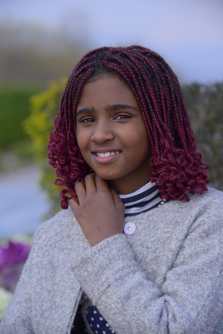 Young Woman With Pink Braided Hair Standing Outside And Smiling 