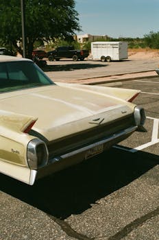 Rear view of a classic Chevrolet Impala parked under the sun, showcasing timeless automotive design.