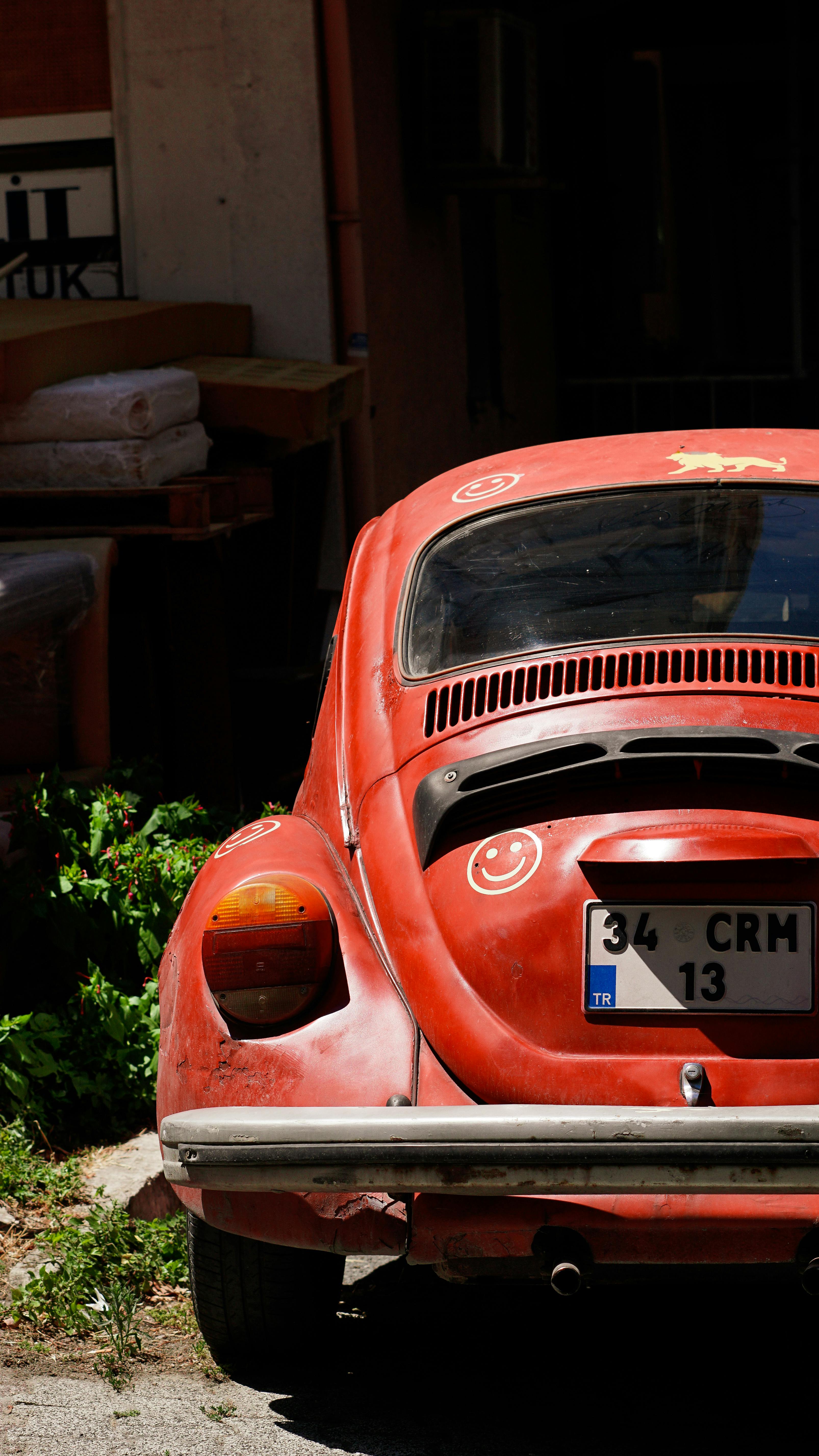 a red volkswagen beetle parked in front of a building