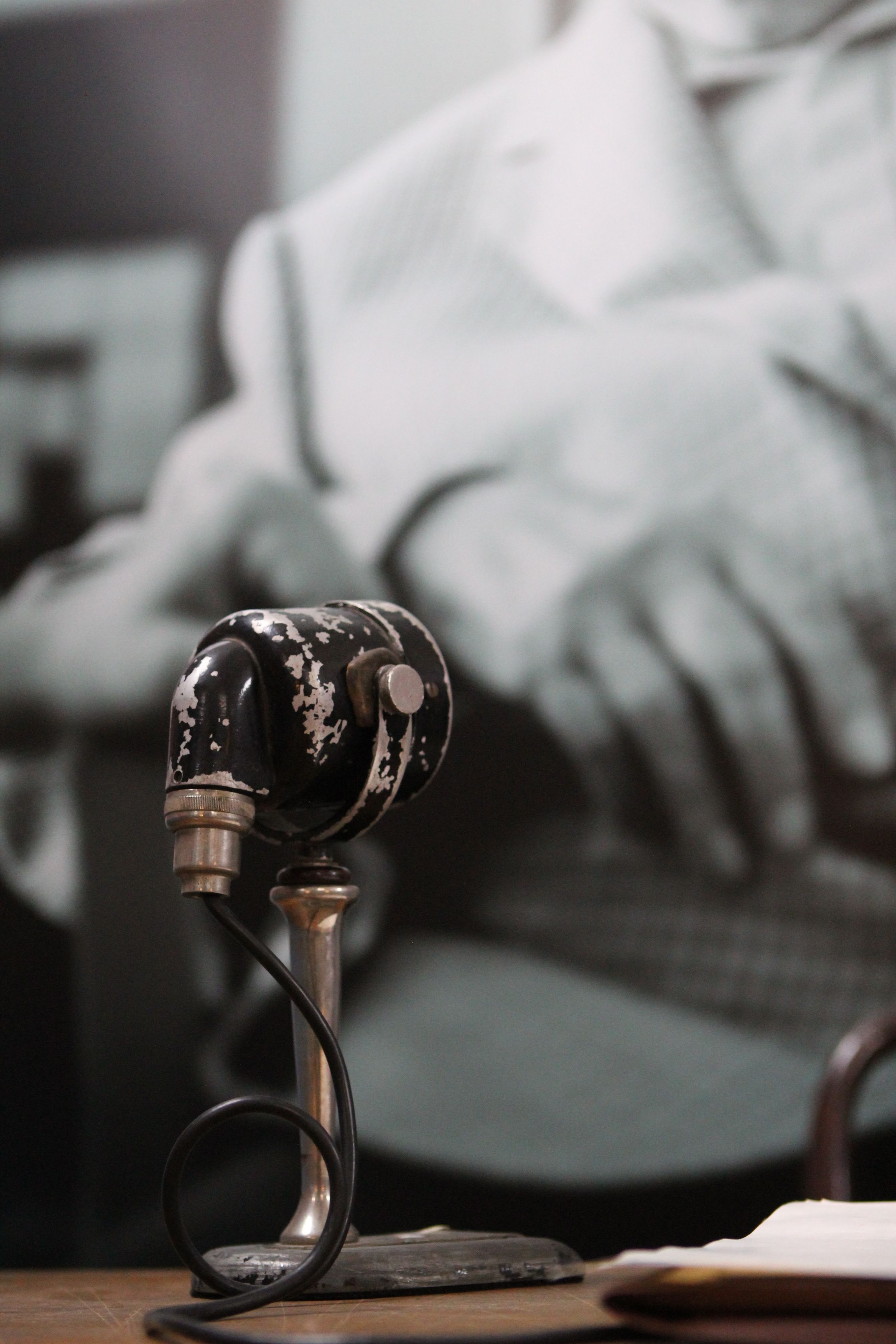 Close-up of a vintage microphone with a retro black and white background, exuding nostalgia.