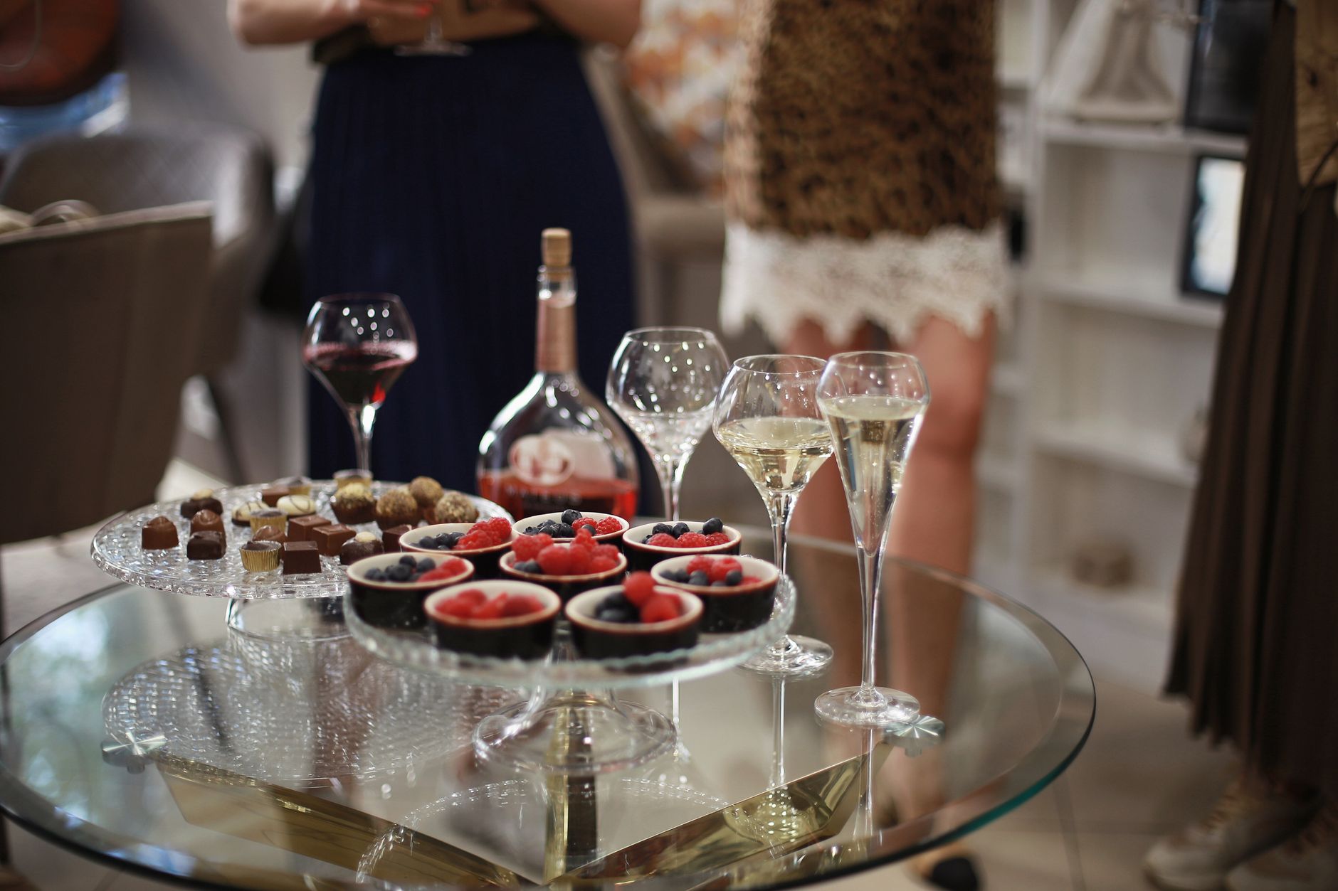 A chilled bottle of sweet white wine with wine glasses on a summer table