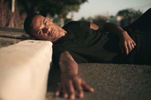 白天，一个男人以休闲的姿势在人行道上休息