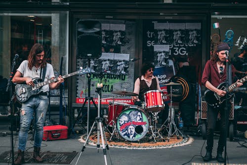 무료 건물 앞에서 공연하는 음악 밴드 스톡 사진