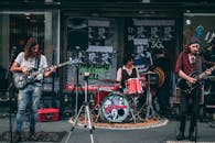 独立乐队在街头现场表演，吉他手和鼓手为人群带来娱乐