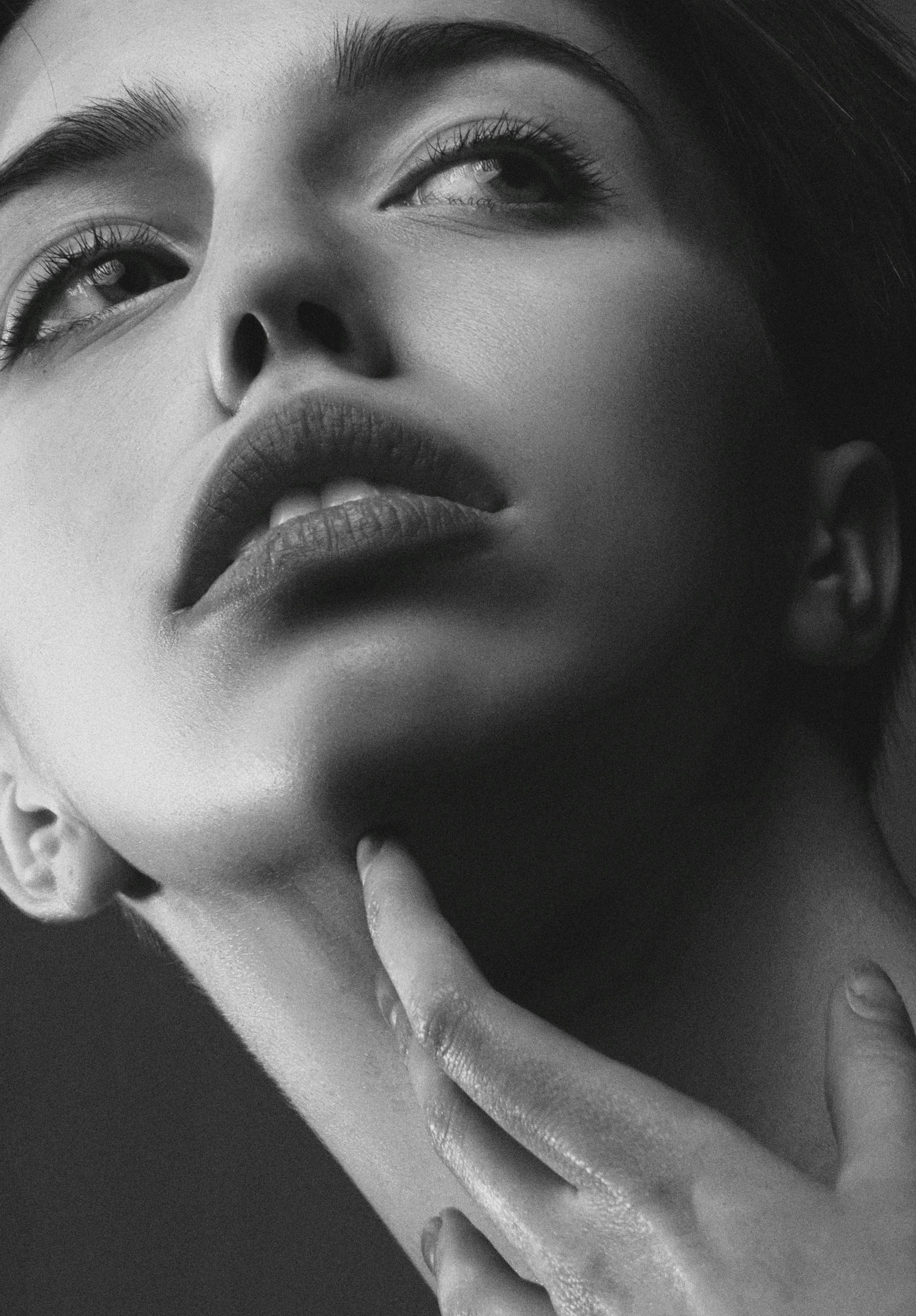 grayscale photography of woman rubbing her neck