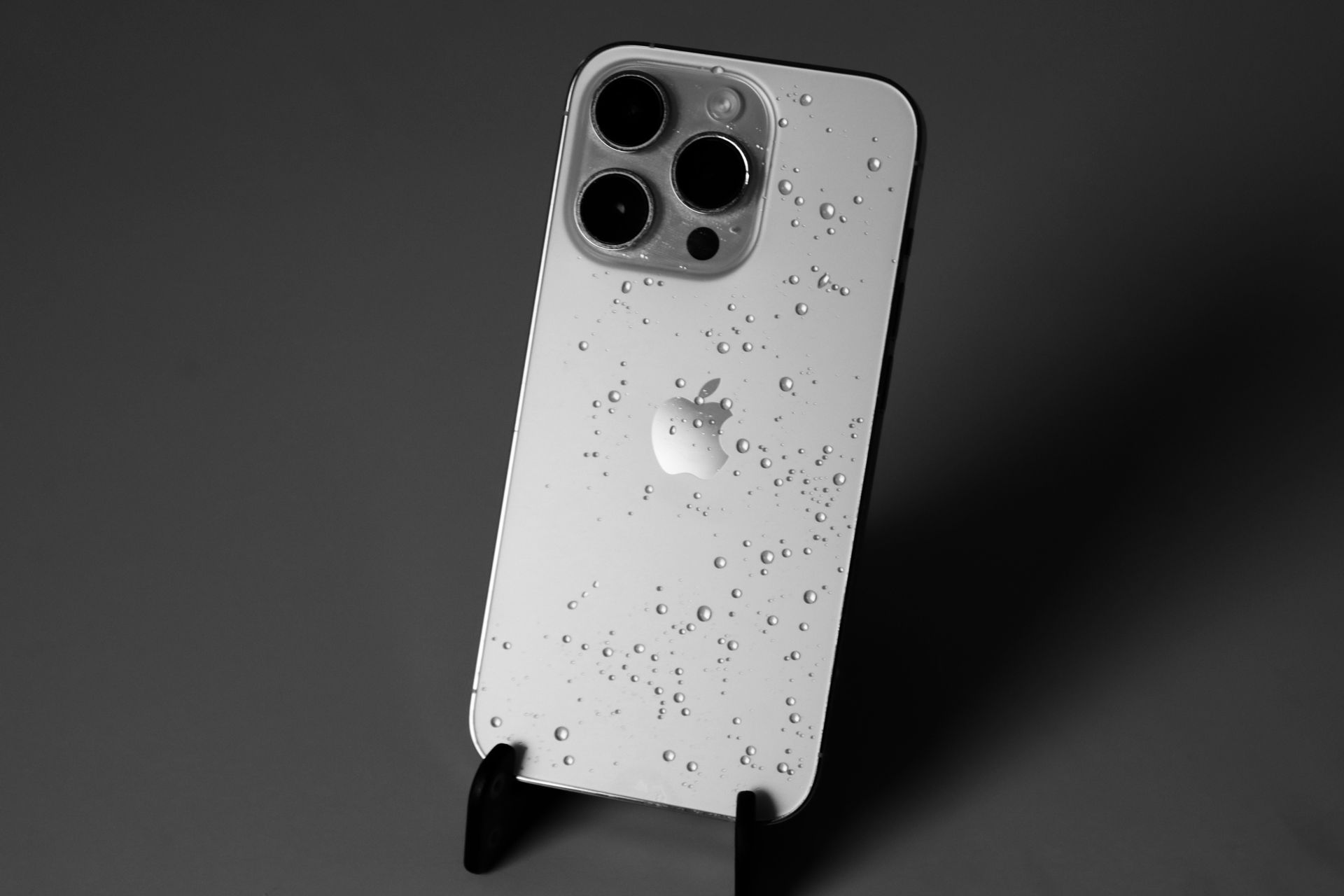 Close-up of a sleek smartphone with water droplets, emphasizing its design and technology.