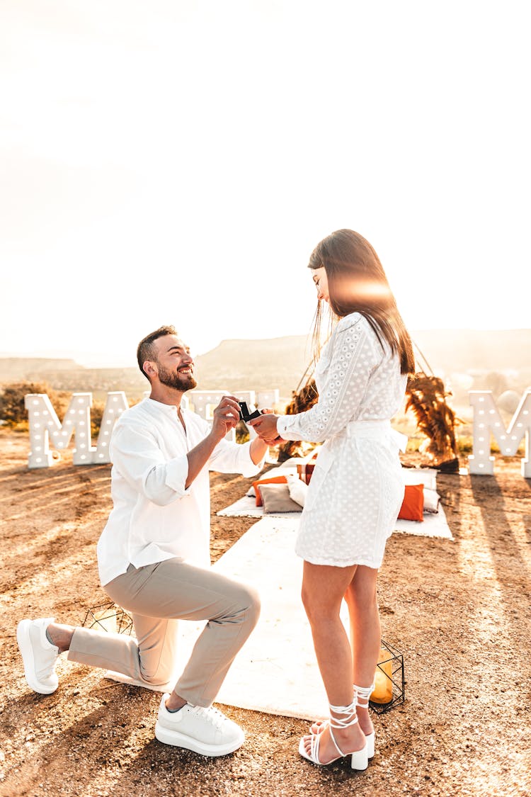 A Man Proposing To A Woman Outside At Sunset 