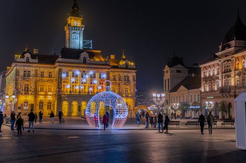 Free A festive night scene in Novi Sad, Serbia, showcasing lit-up historical buildings and seasonal decorations. Stock Photo