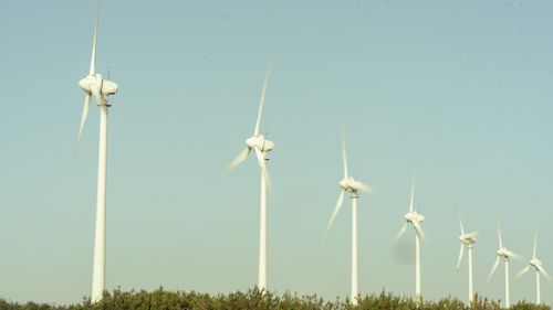 Free Row of wind turbines spinning on a clear day at Bozcaada, Çanakkale, Türkiye. Stock Photo