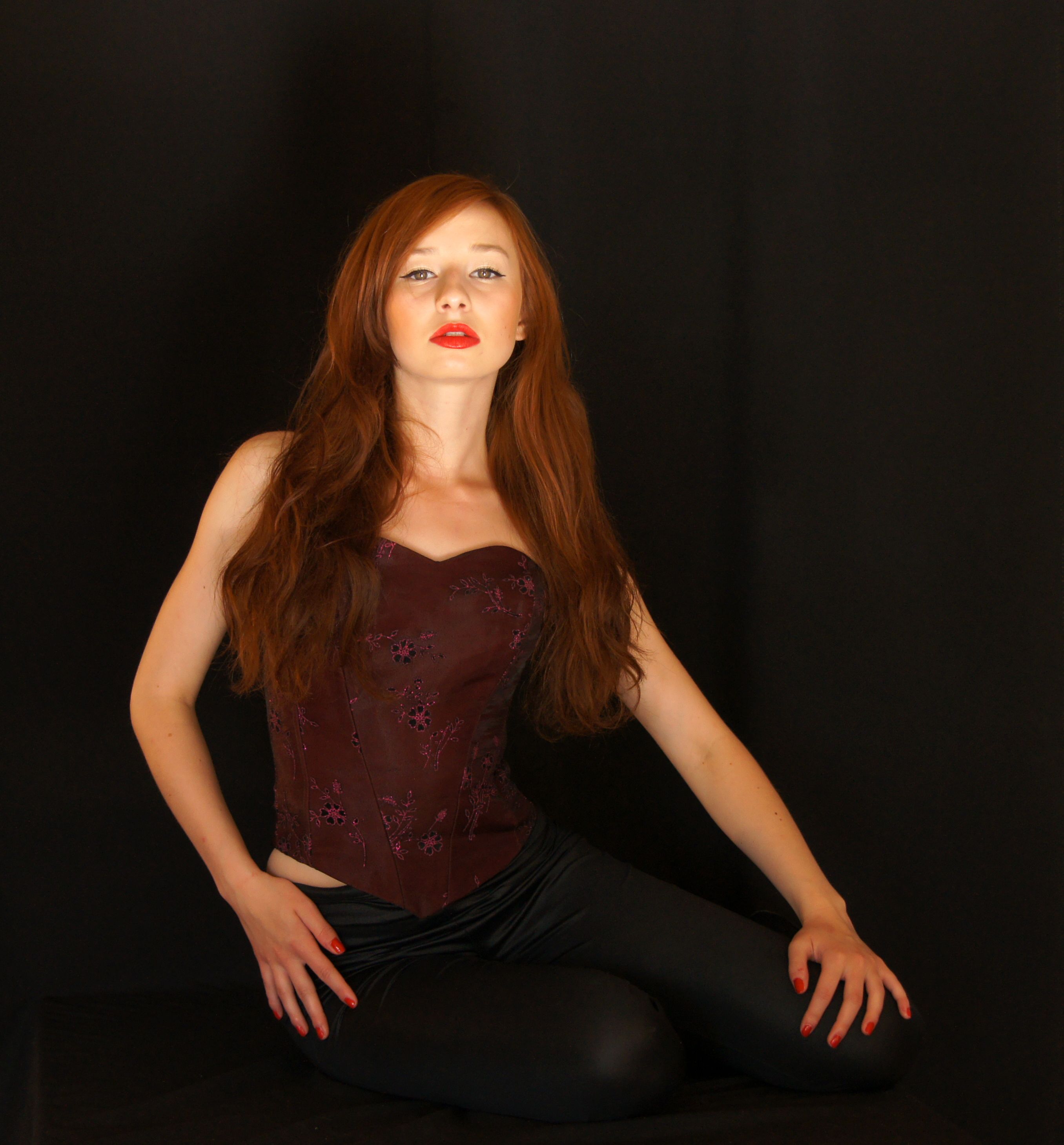 A woman with red hair posing in a black outfit · Free Stock Photo