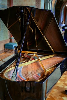 Close-up of an elegant grand piano in a historic castle interior, showcasing intricate details.