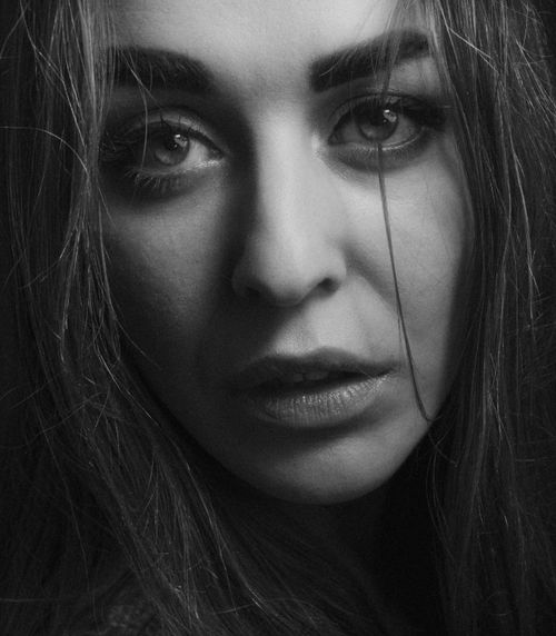 Free Close-up black and white portrait of a woman with long hair and expressive eyes. Stock Photo