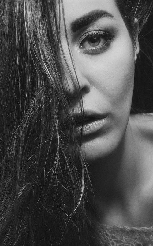 Free Close-up black and white portrait of a woman with long hair, conveying emotion. Stock Photo