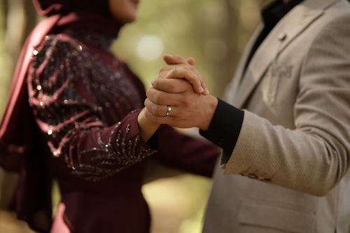 Free A close-up of a Muslim couple gently holding hands, focusing on love and elegance. Stock Photo