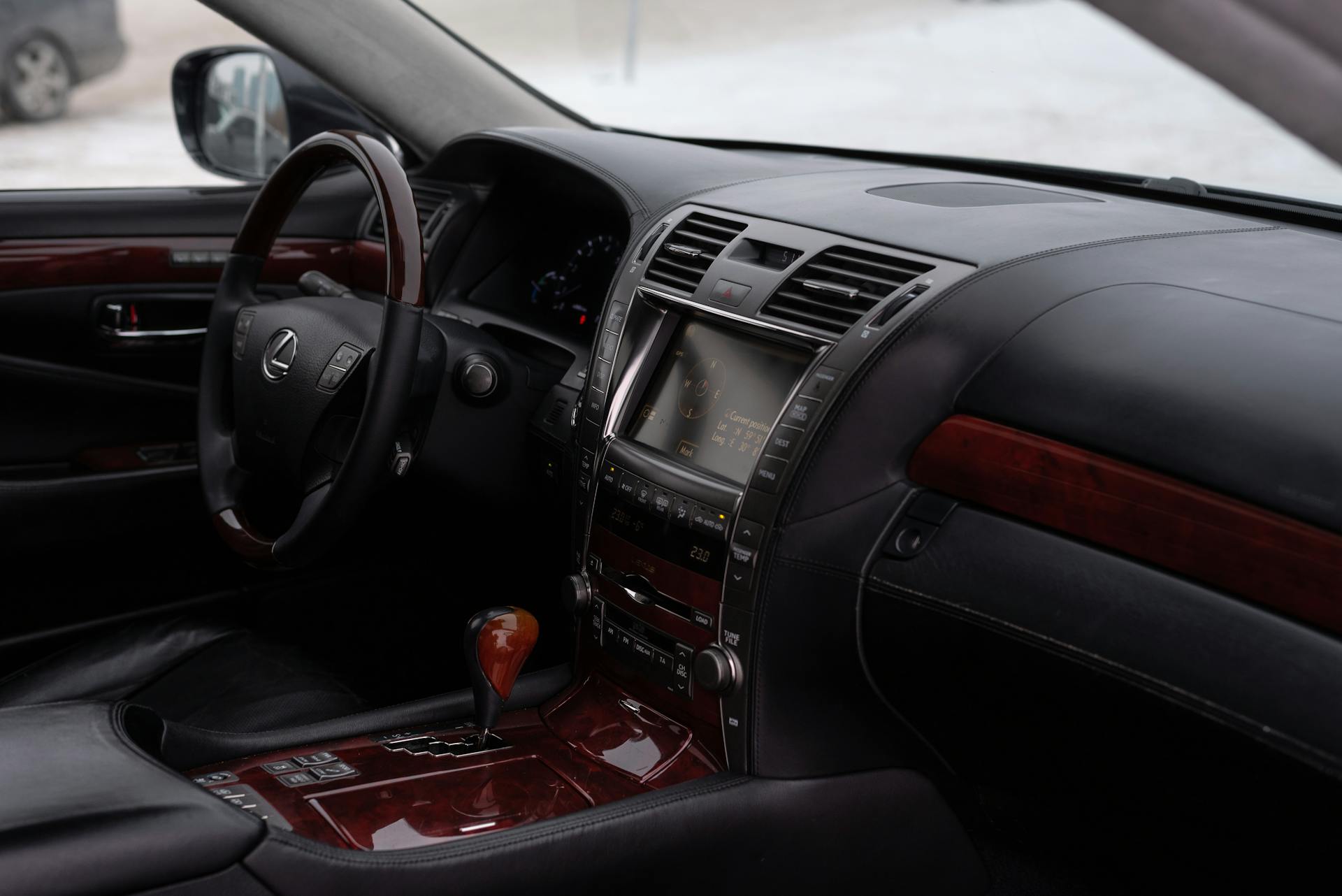 Explore the luxurious interior of a Lexus vehicle featuring a sophisticated dashboard and wooden trim accents.