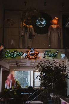 Warm and inviting café interior in Ankara, featuring neon signs and modern design elements.
