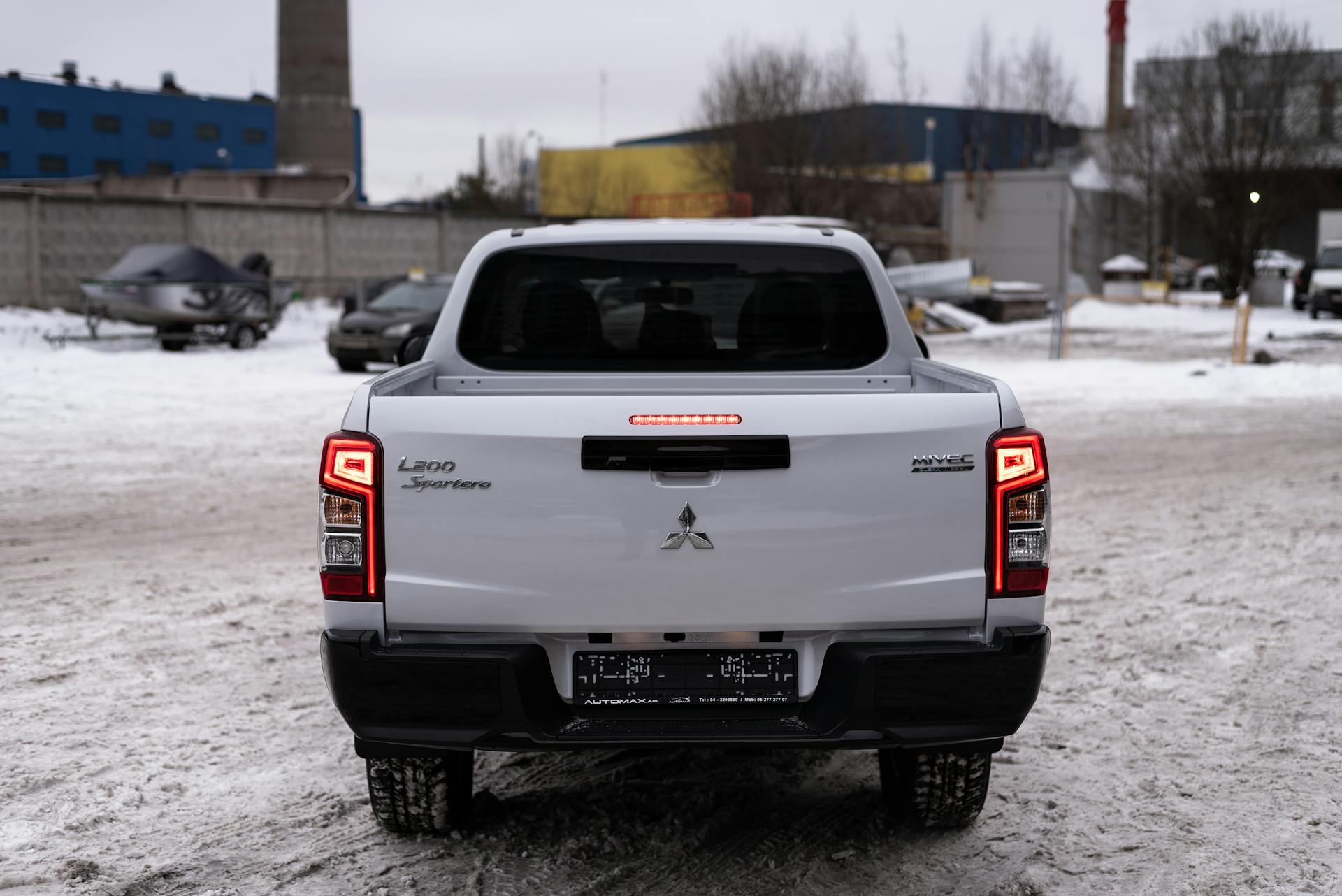 Mitsubishi L200 pickup truck parked on a snowy urban street during the winter.
