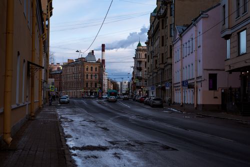 Free A moody winter street scene featuring historical buildings and wet asphalt in a traditional urban setting. Stock Photo
