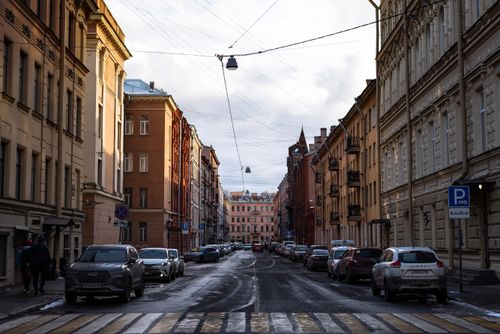 Free An urban street lined with cars and traditional architecture in winter. Stock Photo