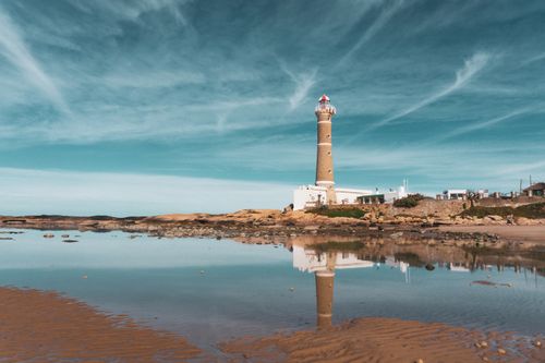 Free Beautiful seaside view of Faro de José Ignacio lighthouse reflecting in the calm water. Stock Photo