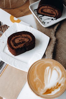 Tasty chocolate Swiss roll paired with a latte, perfect for a sweet treat.