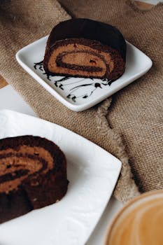 A tempting close-up of a chocolate Swiss roll cake on a rustic burlap backdrop.