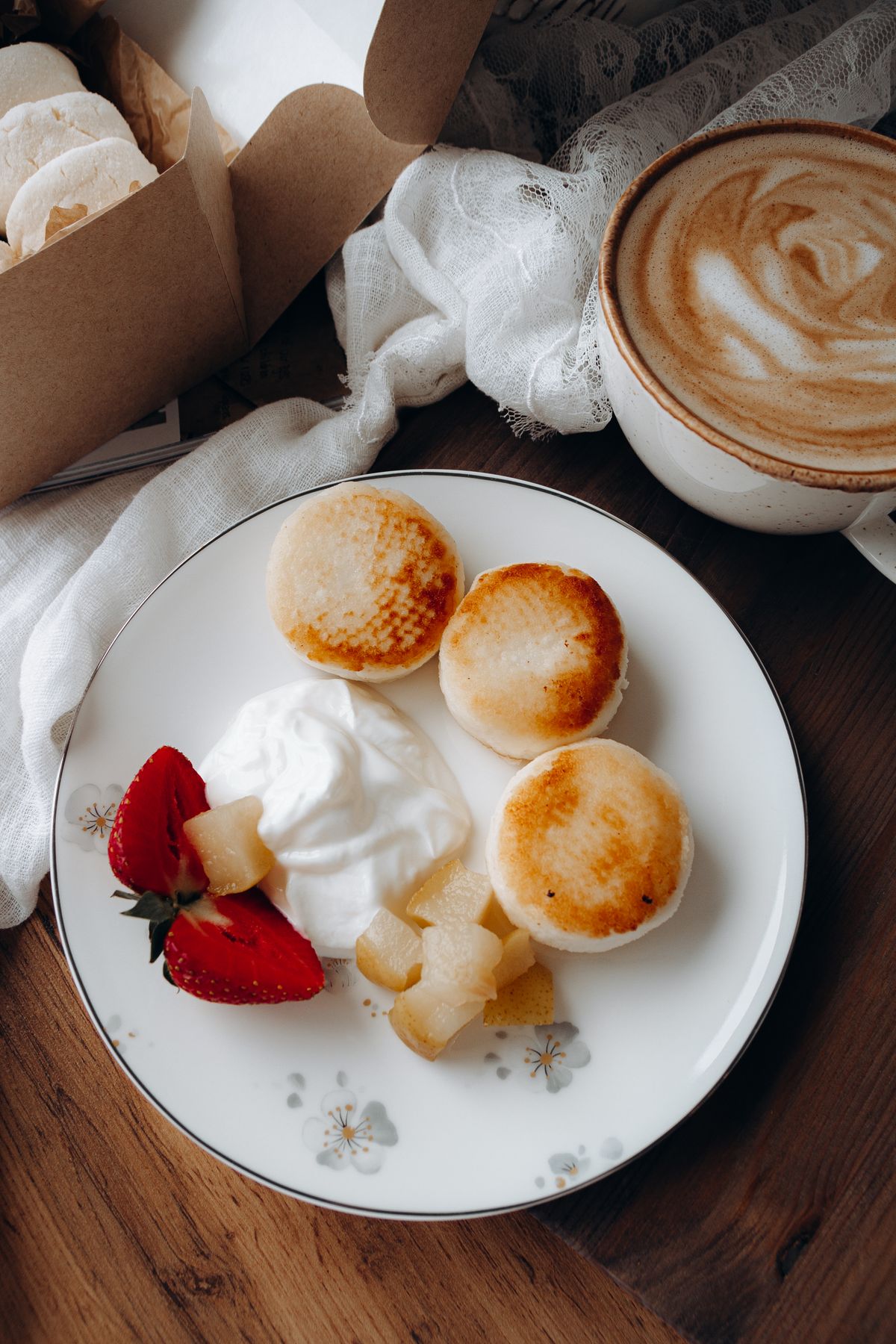 Sweet buns on a plate served with cream and fruit