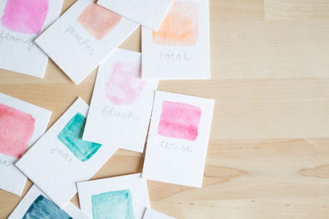 Hand-labelled watercolor swatch cards on a wooden desk — photo by Fiona Murray on Pexels