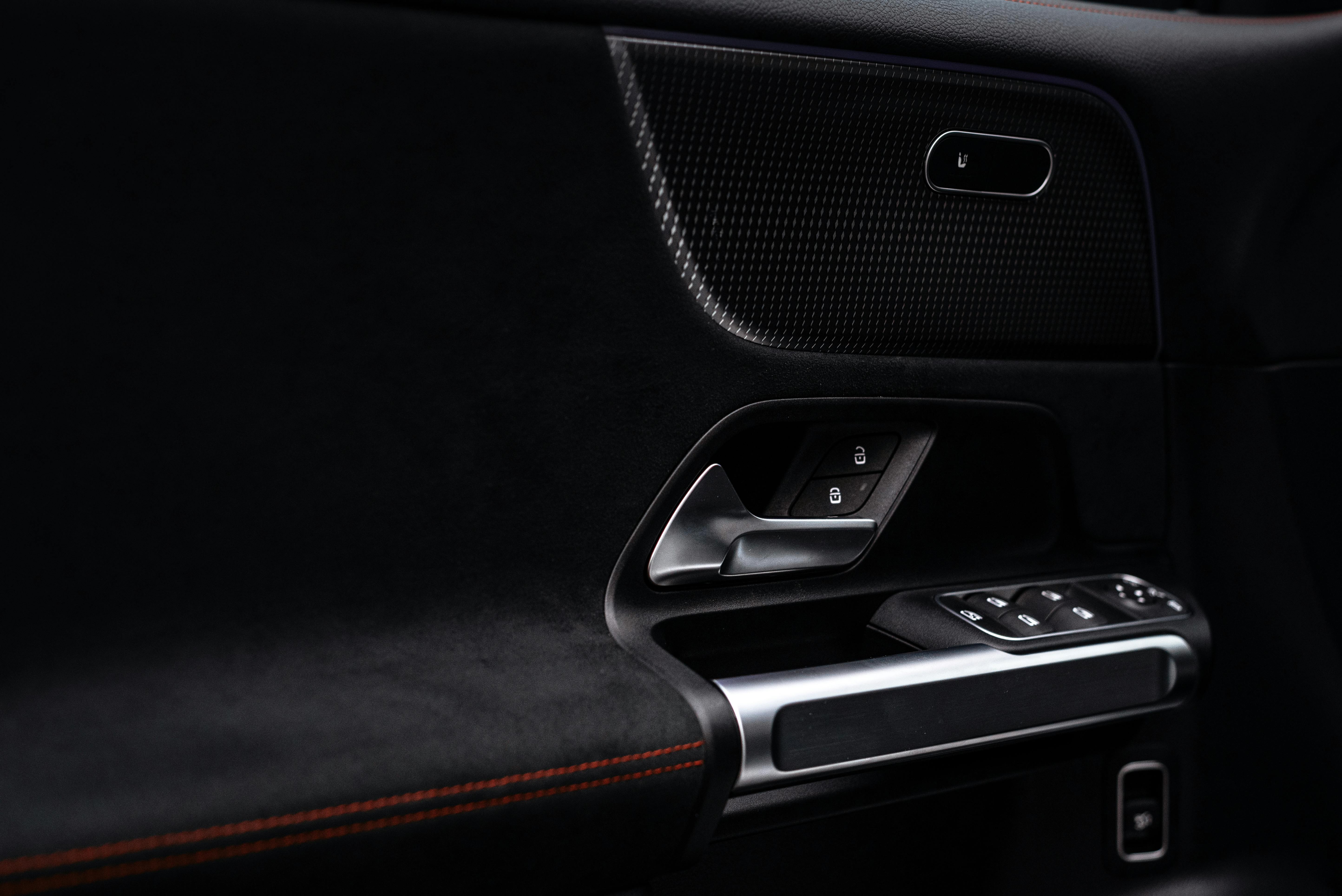 Close-up view of a modern car door panel with handle and electronic controls.