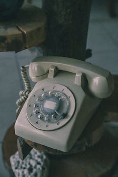 Close-up of a vintage rotary dial telephone with a retro design, highlighting its nostalgic appeal.