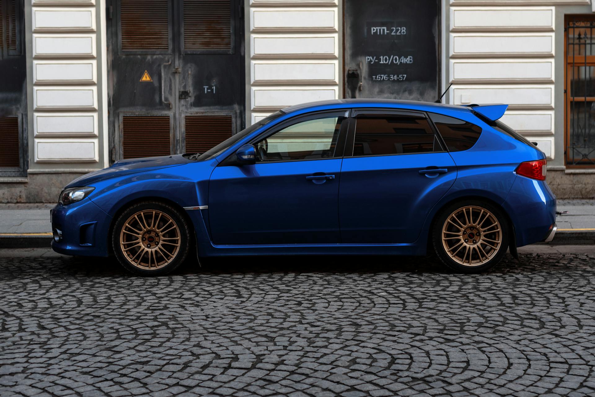 Sapphire Blue Subaru Impreza Parked on a Cobblestone Street