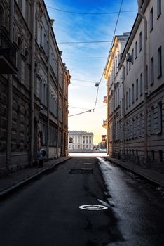 Narrow city alley with traditional architecture and clear blue sky, highlighting urban elegance.