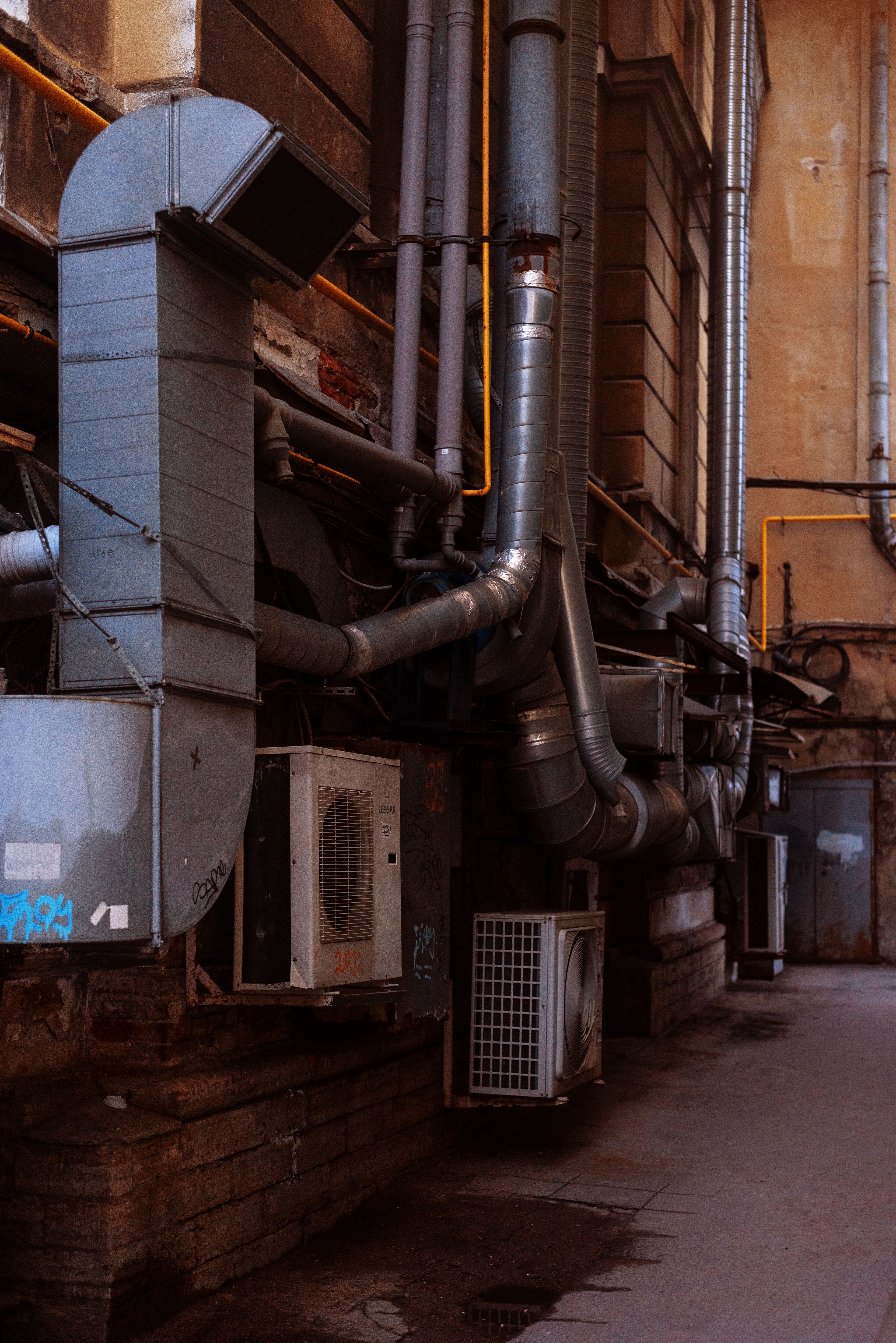 Conduits et équipements de ventilation regroupés à l'arrière d'un bâtiment de centre-ville