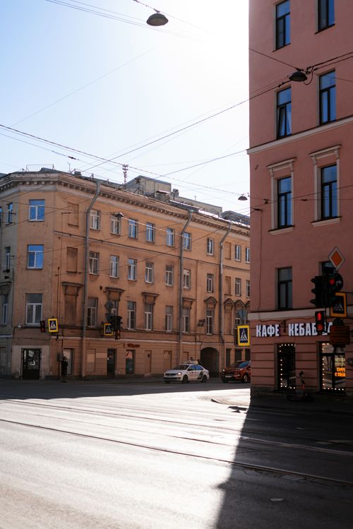 Free City street intersection with a cafe sign under bright sunlight, showcasing architectural structures. Stock Photo