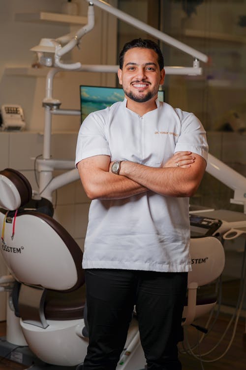 Smiling Dentist Posing by the Treatment Chair