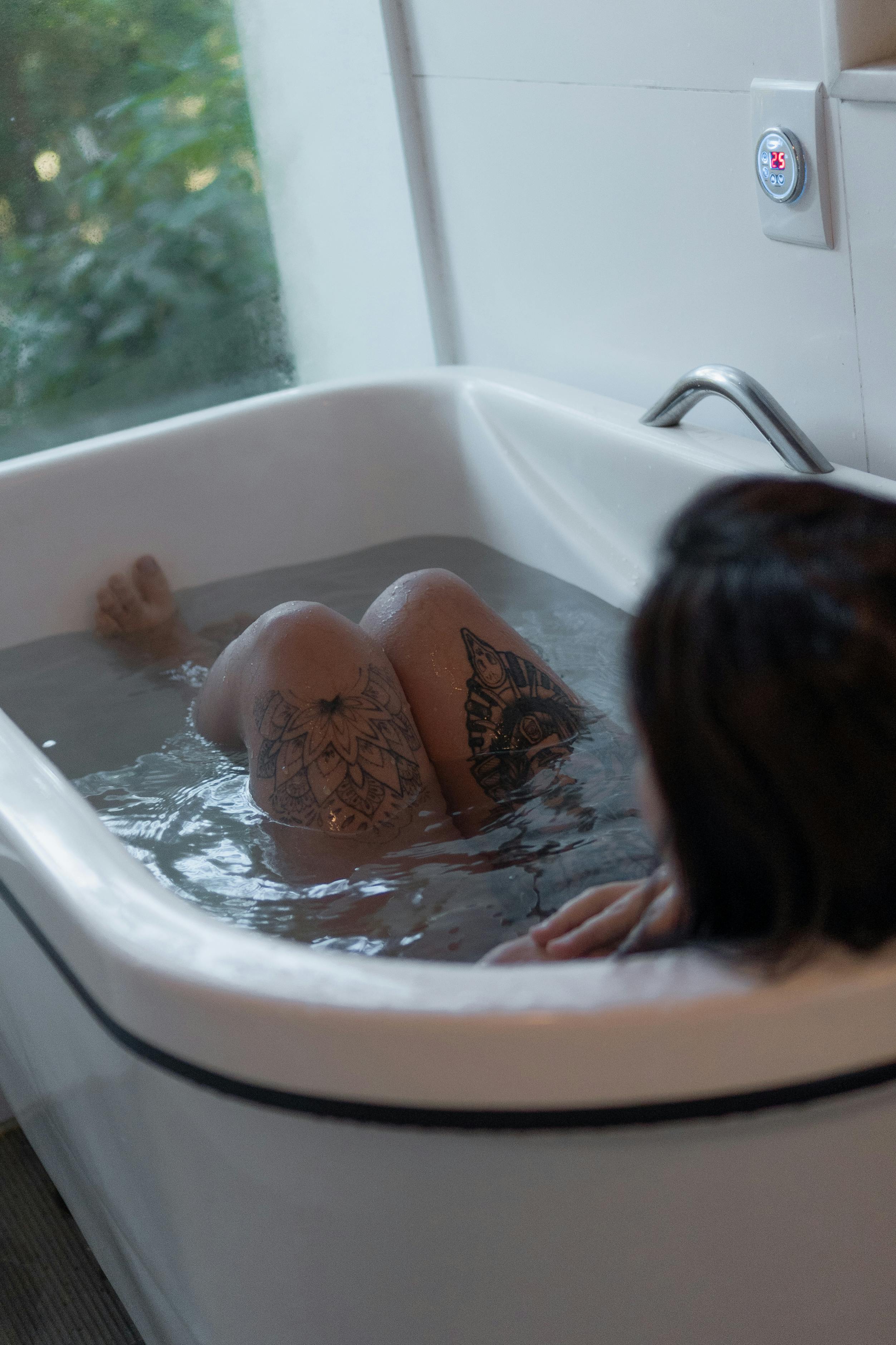 A Girl Lying on Clothes on Bathroom Floor · Free Stock Photo