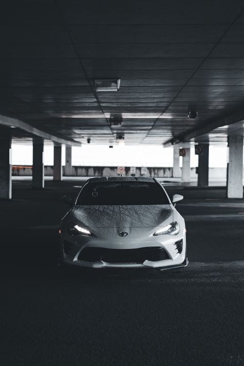 Free Stylish white sports car in a dimly lit underground parking area, showcasing urban elegance. Stock Photo